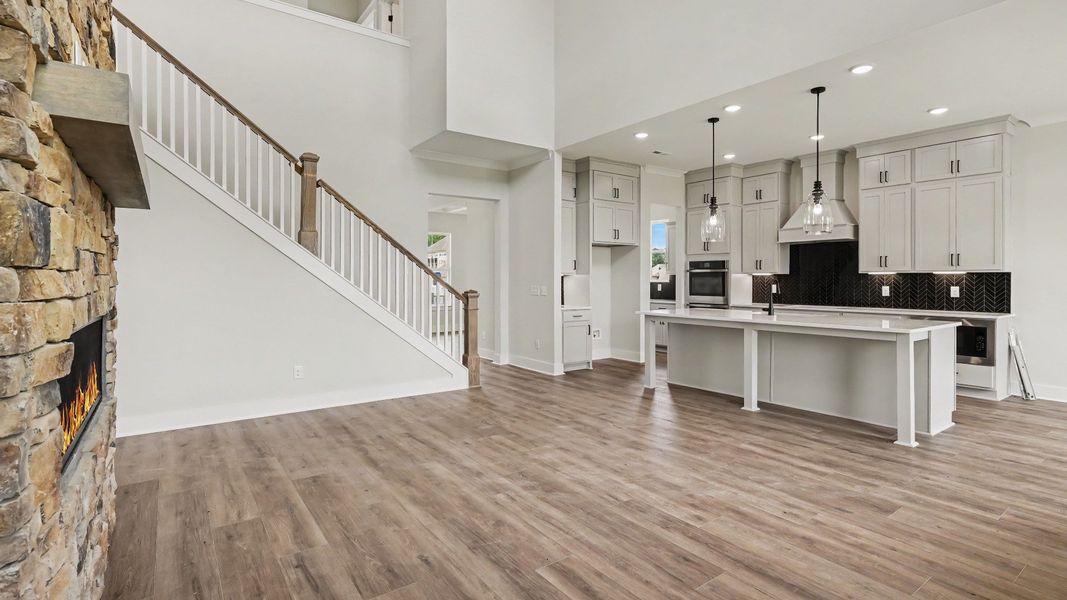 Gathering room with high ceilings, bright natural lighting from windows, and view of kitchen Gathering room with high ceilings, bright natural lighting from windows, and view of kitchen