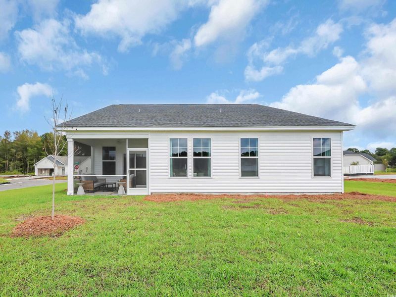 Back of house with a yard, a sunroom, and roof with shingles