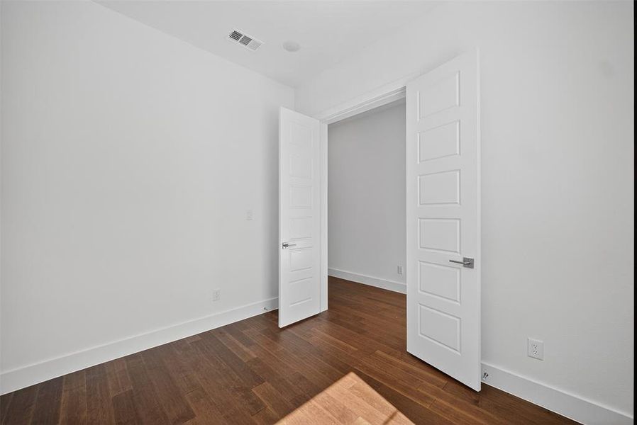 Unfurnished bedroom featuring baseboards and dark wood finished floors