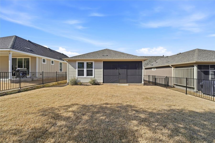 Back of property featuring a fenced backyard, a sunroom, and roof with shingles