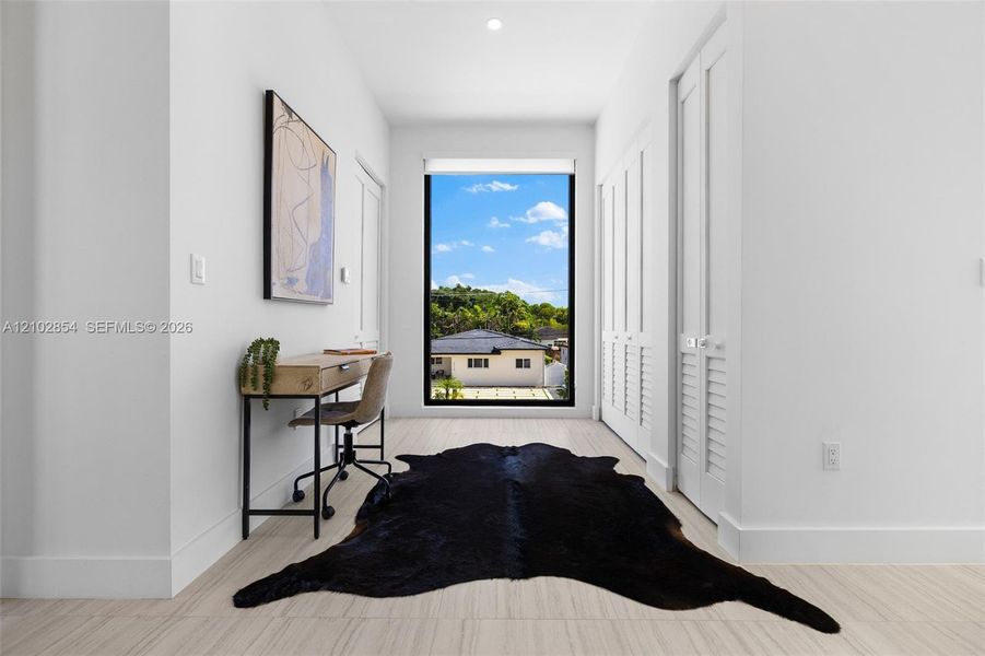 Floor-to-ceiling fixed window, neutral wall-to-wall tiling, and dual louvered closet doors