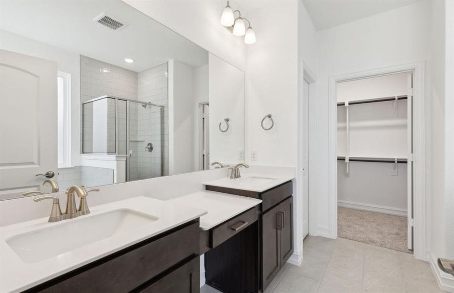 Elegant owner's bathroom with dual vanity *real home pictured