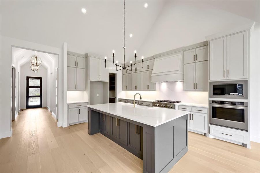 Gourmet kitchen with a large central island featuring a white countertop and contrasting base cabinetry Gourmet kitchen with a large central island featuring a white countertop and contrasting base cabinetry