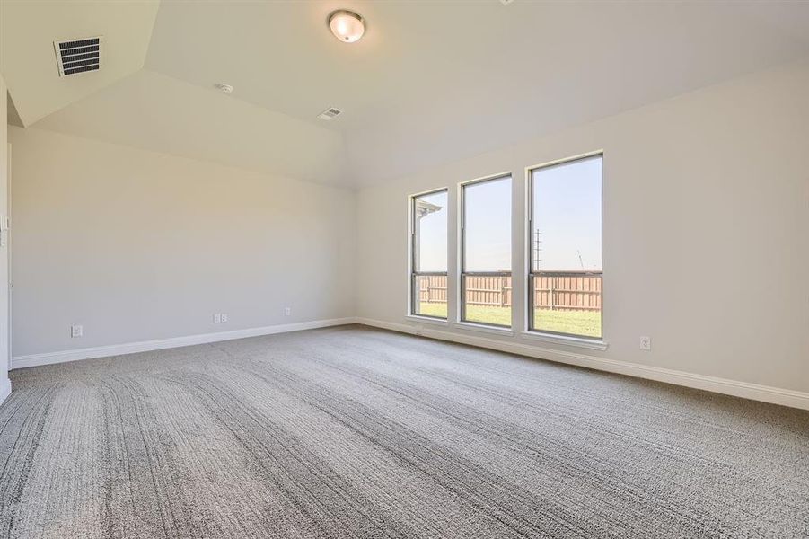 Unfurnished room featuring carpet floors and lofted ceiling