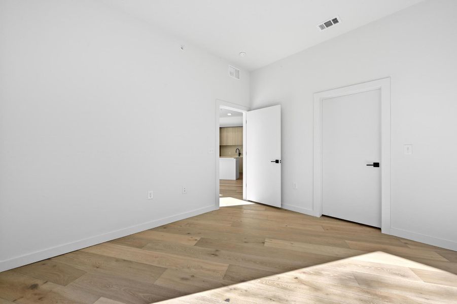 Unfurnished bedroom with light wood-type flooring and baseboards Unfurnished bedroom with light wood-type flooring and baseboards