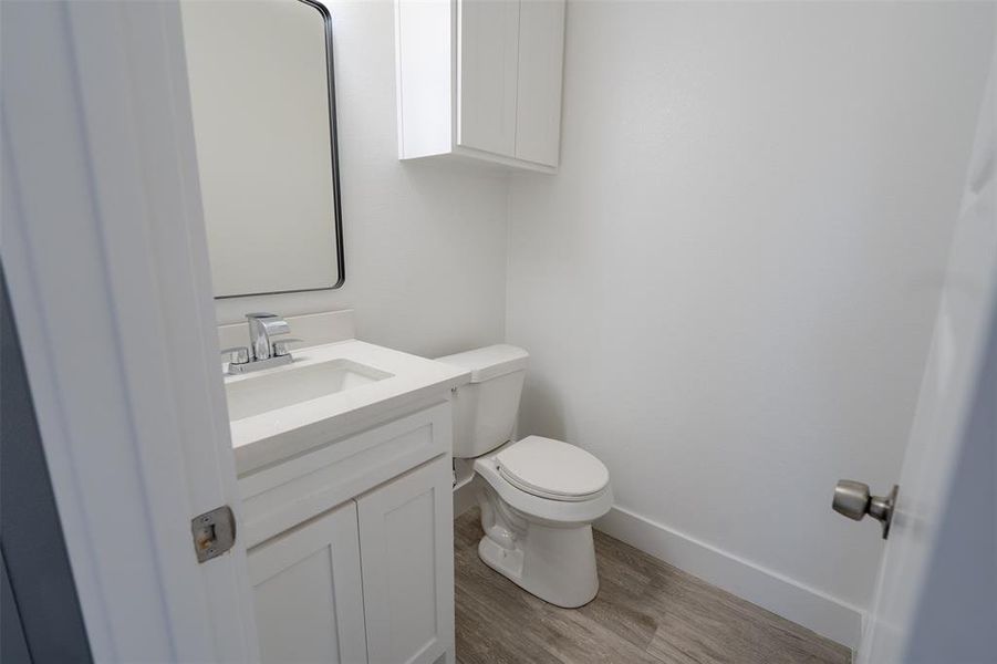 Half bathroom featuring vanity and wood finished floors Half bathroom featuring vanity and wood finished floors