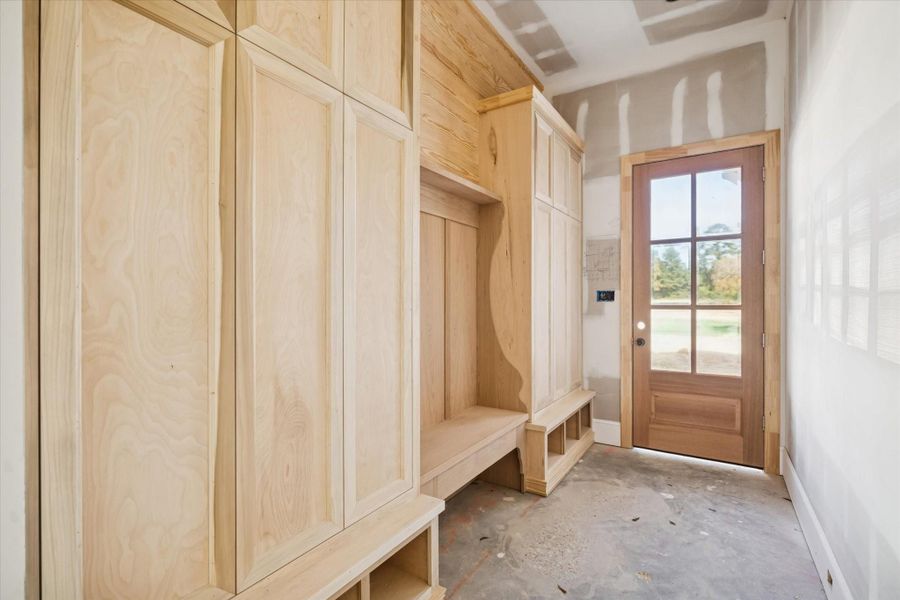 The side entry features additional built-ins for storage and drop-off, conveniently located as you enter from the exterior. Natural light brightens the space, bringing warmth to this hard-working area of the home. A practical, well-designed extension of the mudroom.