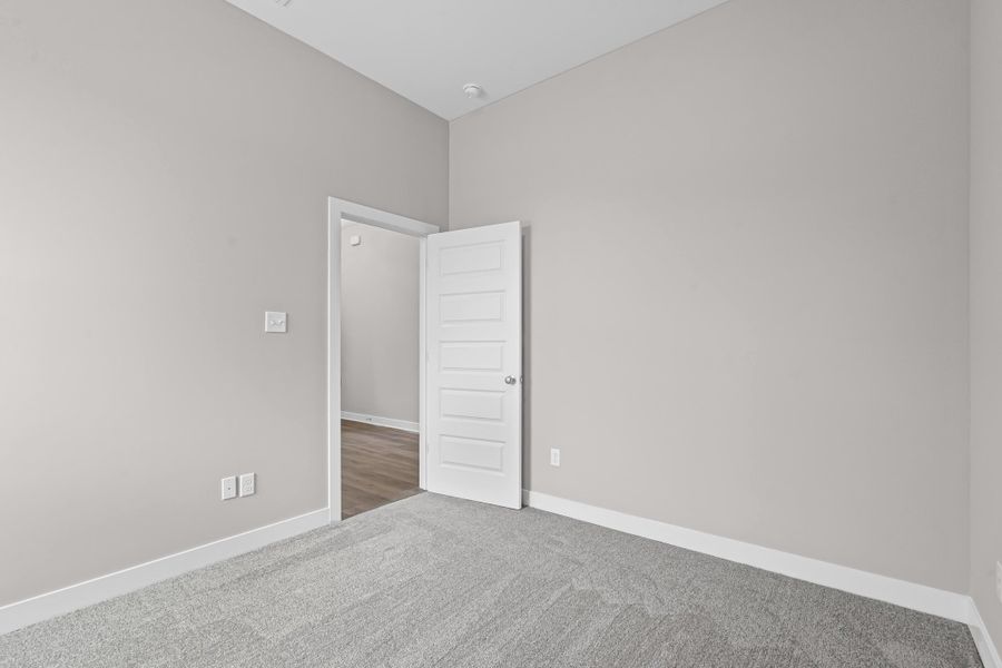 Spare room featuring carpet flooring and baseboards