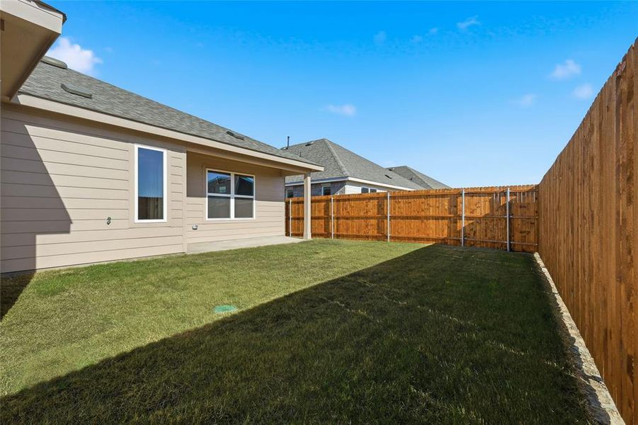 Fenced backyard with a patio
