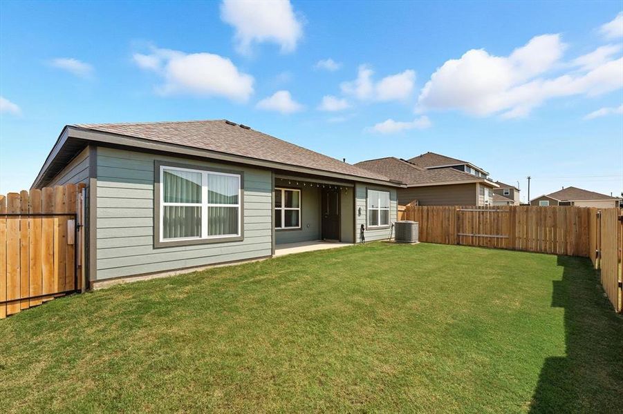 Rear view of property with a fenced backyard, a patio, and a shingled roof