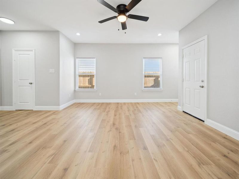 Empty room featuring light wood-type flooring, plenty of natural light, and ceiling fan