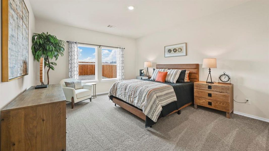 Bedroom with light colored carpet and baseboards
