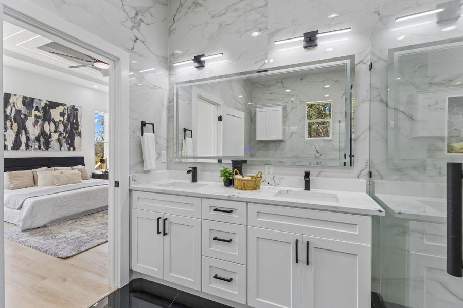 Gleaming marble walls and a spacious double vanity elevate this contemporary bathroom.