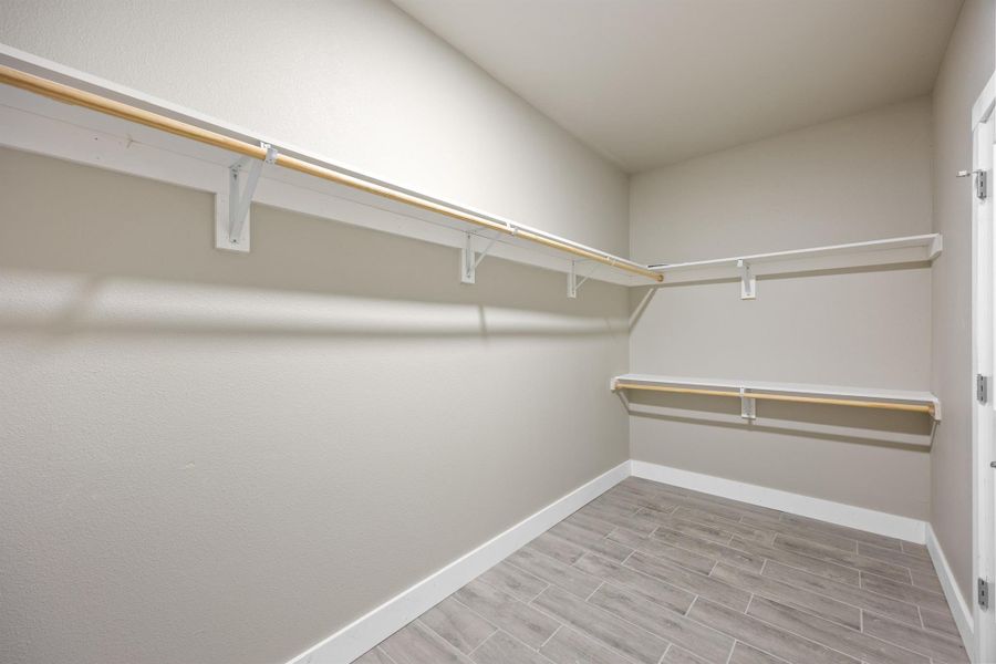 Walk in closet featuring wood finished floors Walk in closet featuring wood finished floors