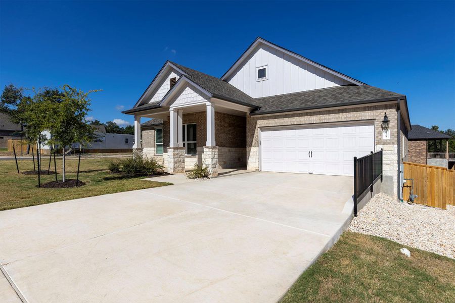 Craftsman inspired home with driveway, covered porch, board and batten siding, a shingled roof, and stone siding