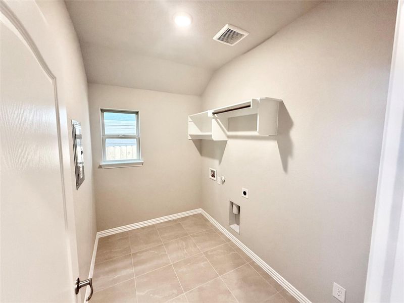 Laundry area featuring electric dryer hookup, light tile patterned floors, and hookup for a washing machine Laundry area featuring electric dryer hookup, light tile patterned floors, and hookup for a washing machine