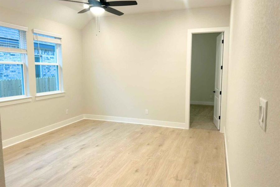 Empty room featuring light wood-style floors and a ceiling fan