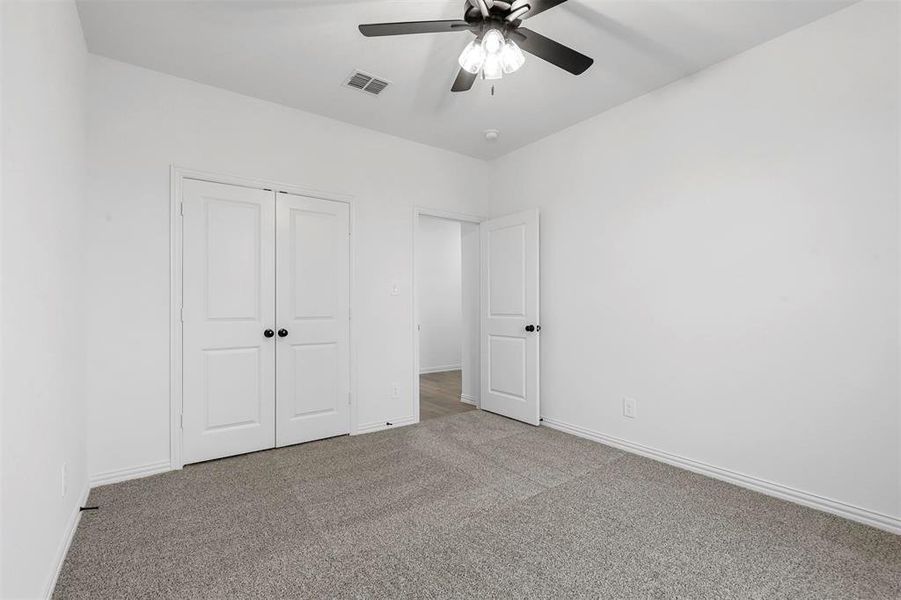 Unfurnished bedroom with carpet floors, ceiling fan, and a closet