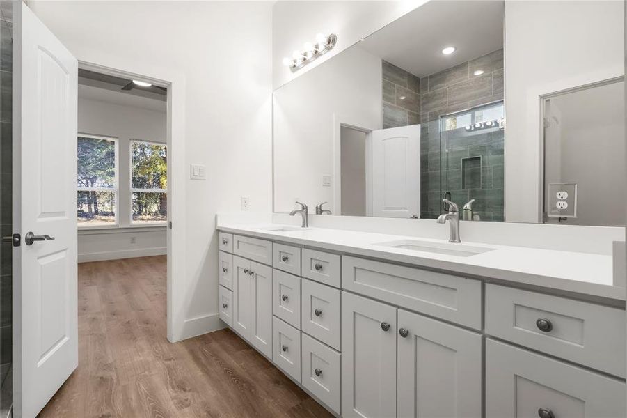 Bathroom featuring hardwood / wood-style floors, vanity, and an enclosed shower