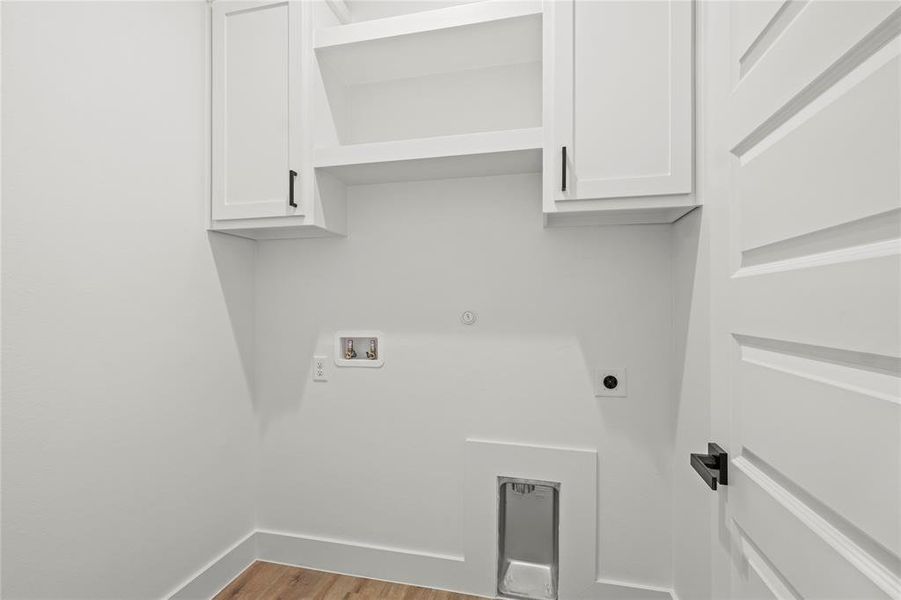 Washroom with washer hookup, hookup for an electric dryer, cabinets, and light wood-type flooring