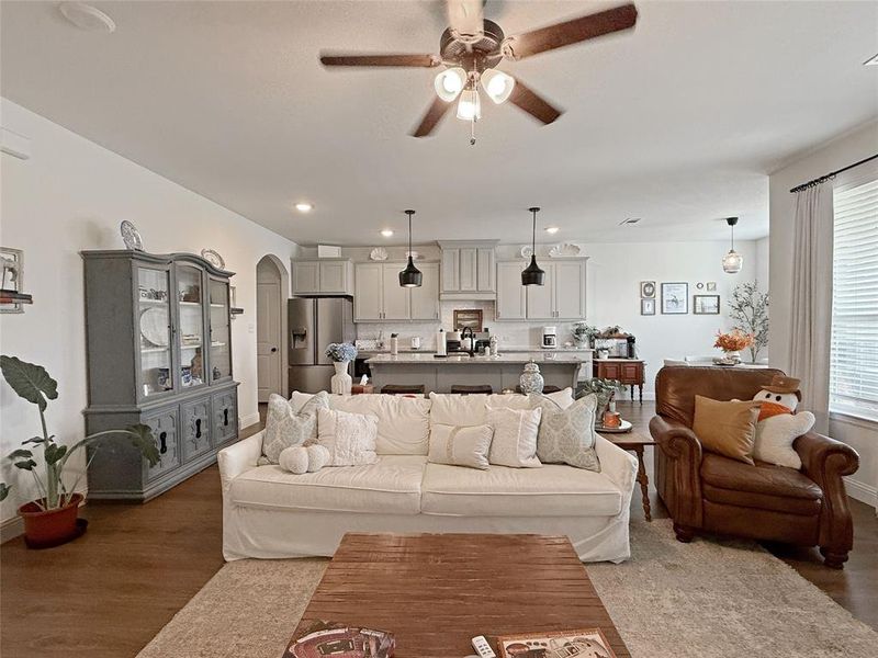 Living area featuring ceiling fan, arched walkways, recessed lighting, and wood finished floors Living area featuring ceiling fan, arched walkways, recessed lighting, and wood finished floors