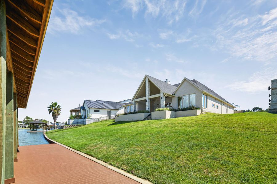 View of the backyard highlighting the home’s exterior architecture and open green space.