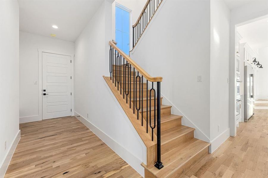 Hallway leading to garage with staircase and a mud nook just beyond. Hard working and pretty!