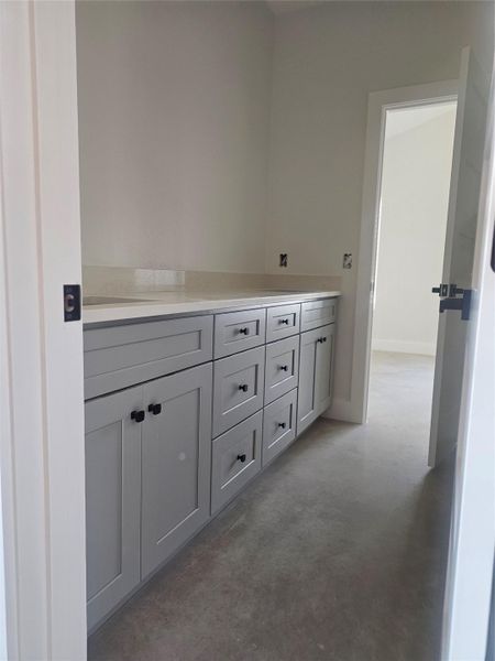 Hallway with concrete flooring and baseboards