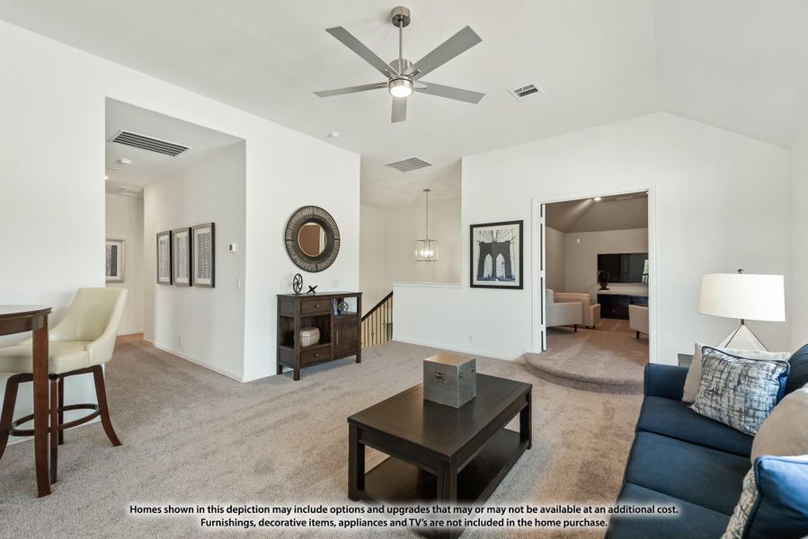 Open upstairs loft area with ceiling fan, carpet, blue sofa, and staircase landing visible nearby.