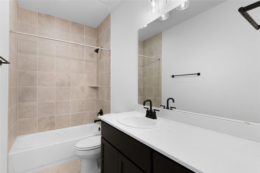 Bathroom featuring vanity, washtub / shower combination, and light tile patterned floors