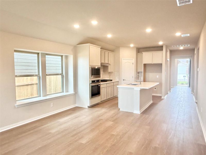 Kitchen featuring a kitchen island with sink, white cabinets, recessed lighting, decorative backsplash, and appliances with stainless steel finishes Kitchen featuring a kitchen island with sink, white cabinets, recessed lighting, decorative backsplash, and appliances with stainless steel finishes