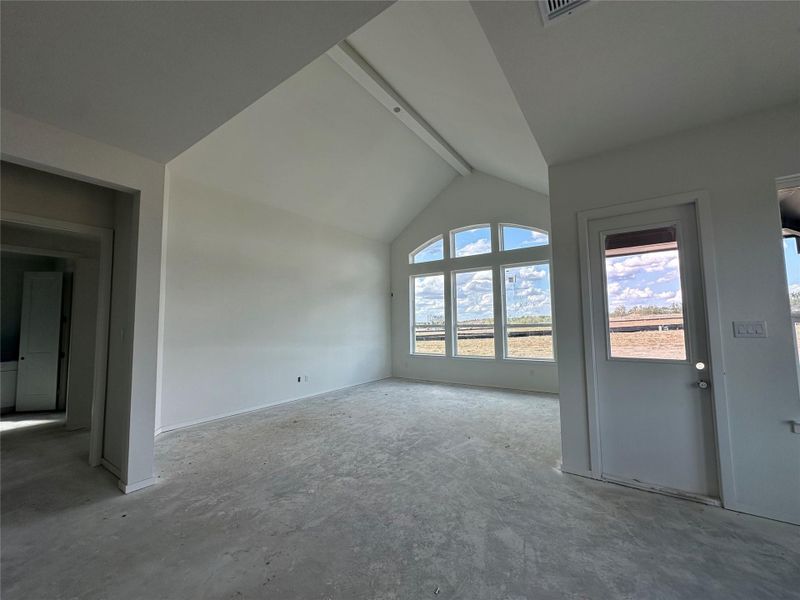 A spacious room features soaring vaulted ceilings and generous fenestration, providing abundant natural light. A spacious room features soaring vaulted ceilings and generous fenestration, providing abundant natural light.