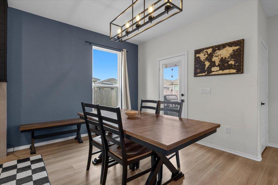 A warm, inviting dining space with natural light and durable wood-like flooring.