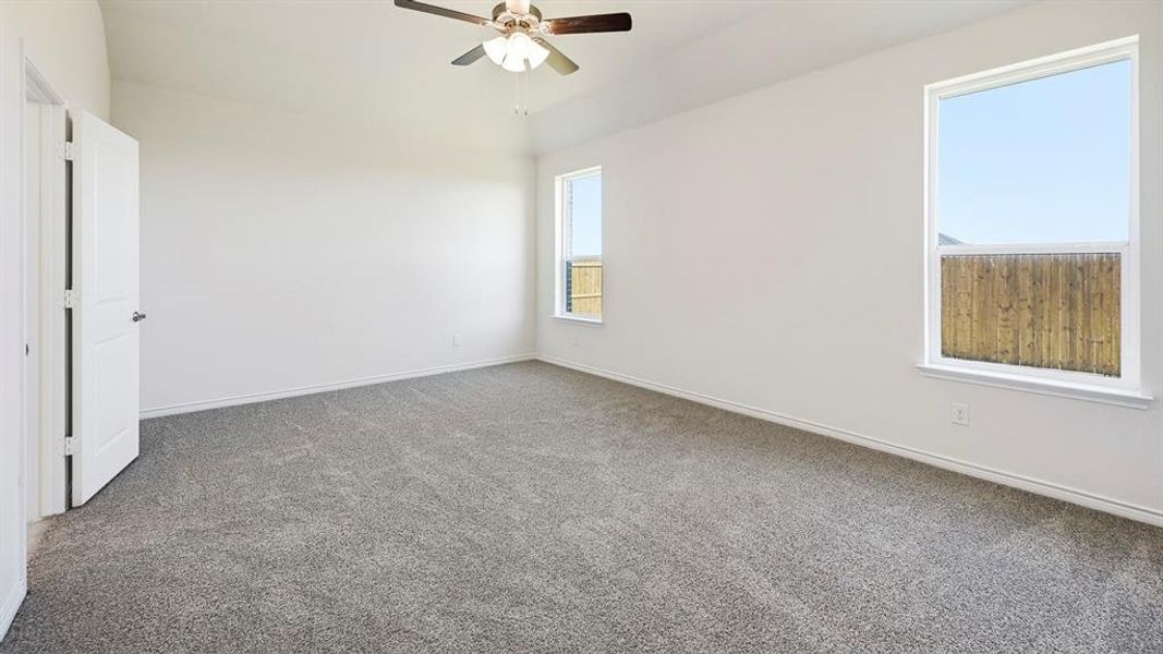 Empty room featuring carpet flooring and a ceiling fan