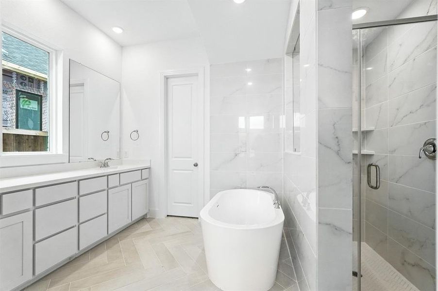 Bathroom featuring vanity, a soaking tub, a shower stall, tile walls, and recessed lighting Bathroom featuring vanity, a soaking tub, a shower stall, tile walls, and recessed lighting