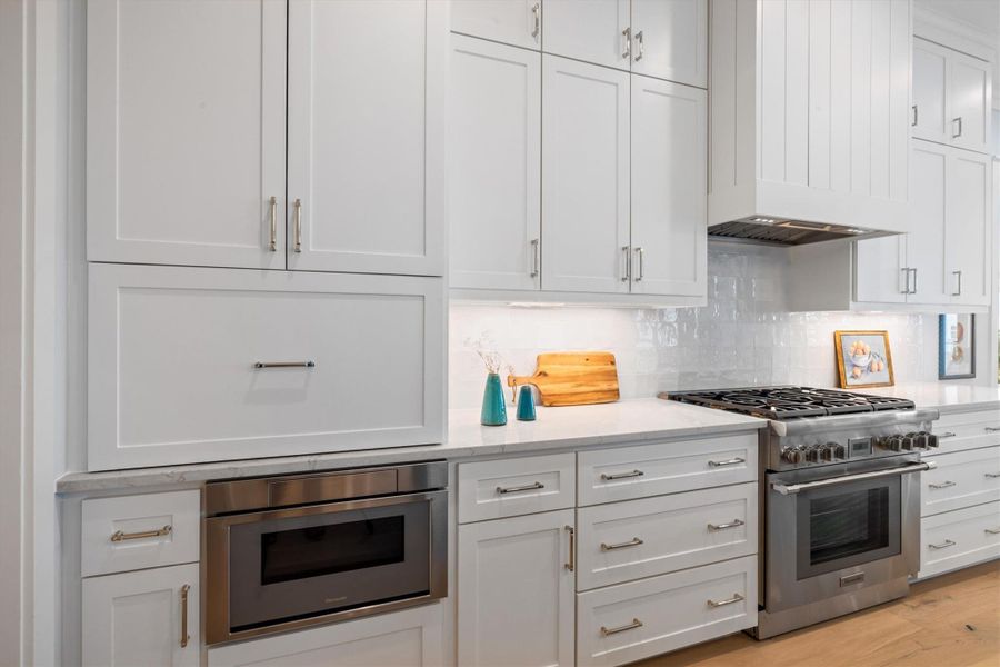 View of Thermador gas range, microwave drawer, and appliance garage.