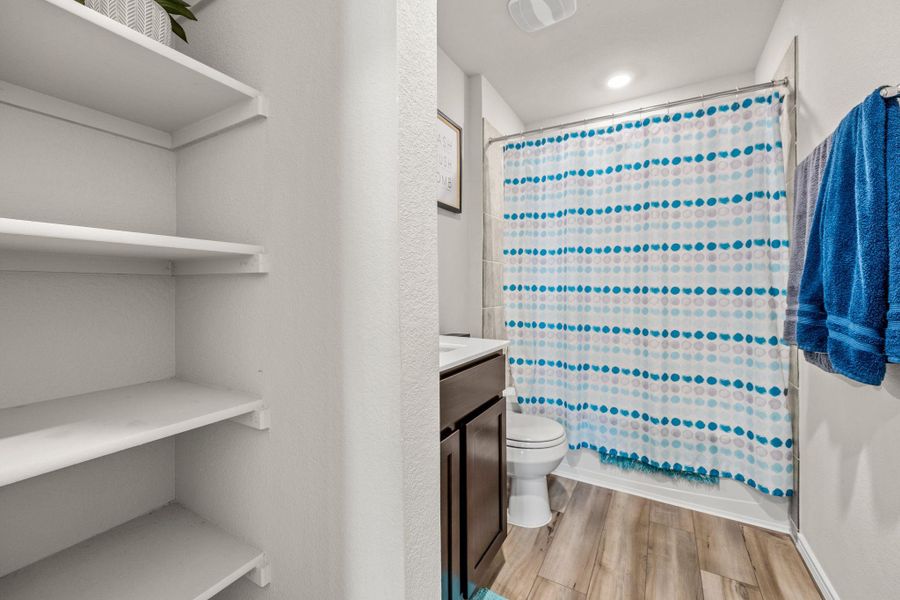 Streamlined storage solutions and a well-appointed shower create a functional and inviting bathroom retreat.