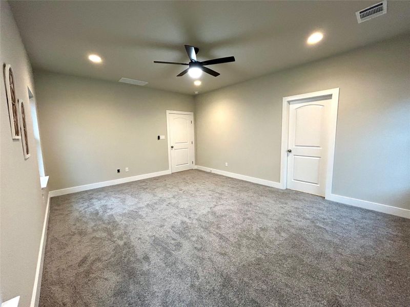 Primary bedroom with recessed lighting.