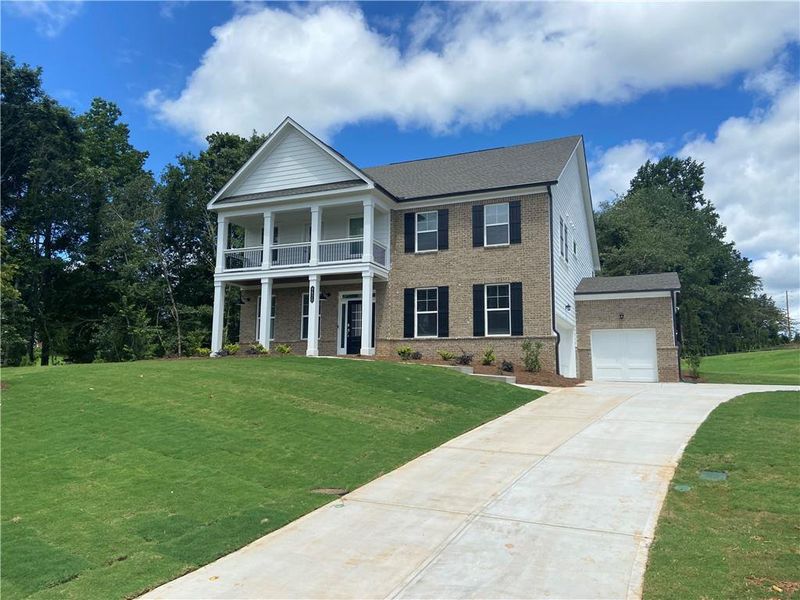 Front exterior of a new home in Estates at Yellow Creek, Cumming, GA, highlighting curb appeal (Image 1). Front exterior of a new home in Estates at Yellow Creek, Cumming, GA, highlighting curb appeal (Image 1).