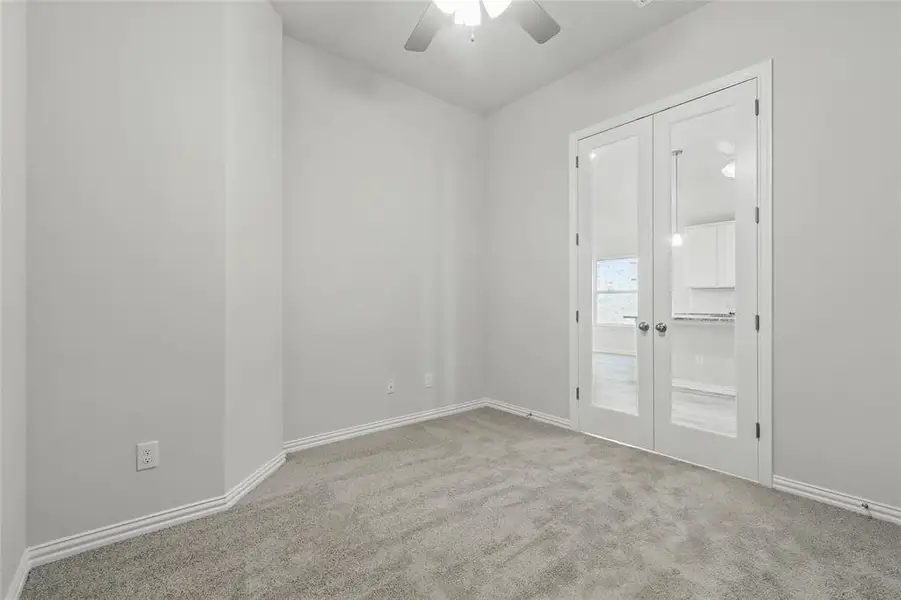 Unfurnished room featuring ceiling fan, carpet flooring, baseboards, and french doors