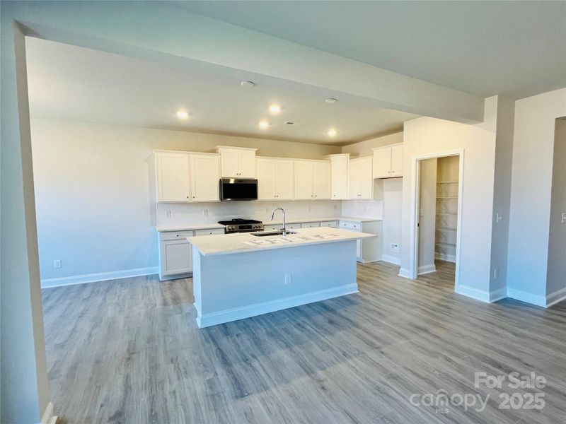 Light and bright kitchen with quartz countertops and gas slide in range