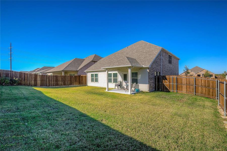 Rear view of house with a yard and a patio area