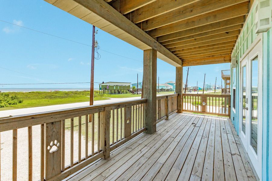 Oversized covered deck extends the home's living space with room for dining, relaxing, and entertaining while enjoying coastal views.