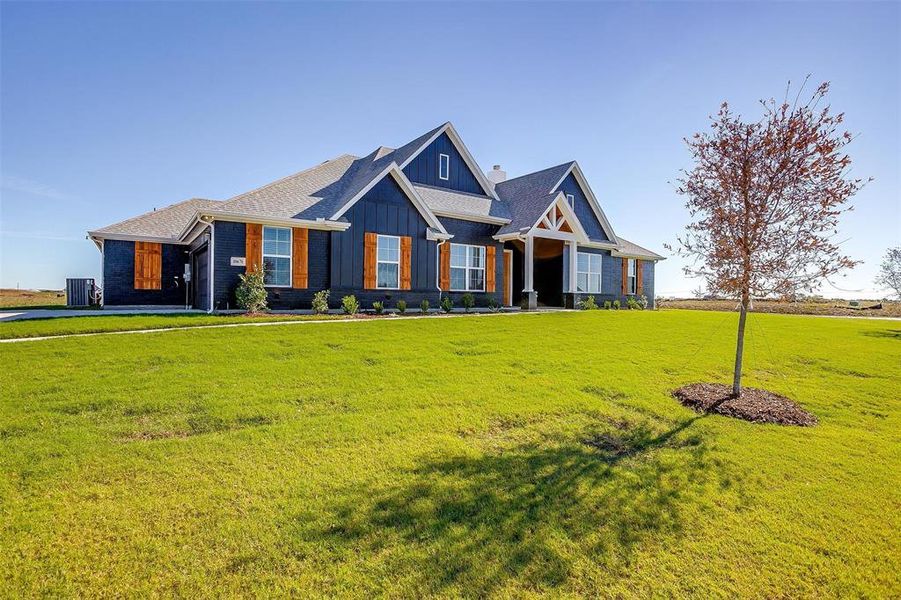 Craftsman inspired home featuring central AC unit and a front lawn