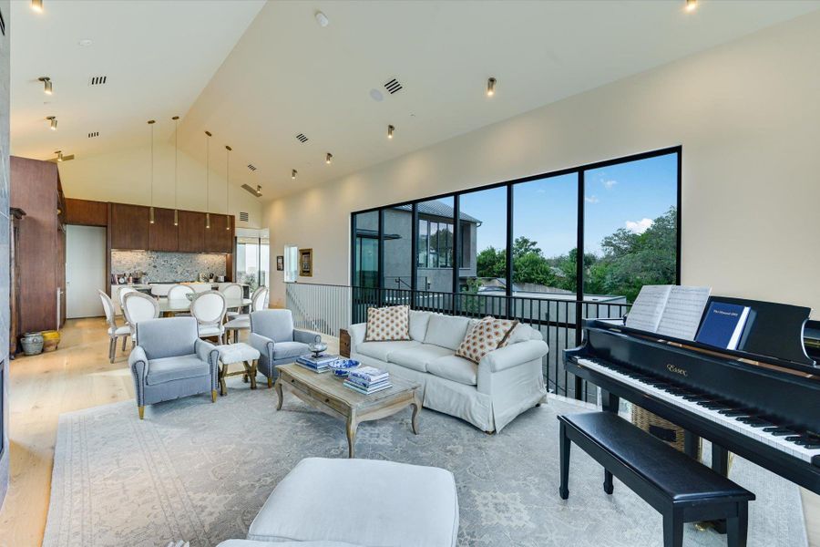 Living area featuring high vaulted ceiling and light wood-style floors