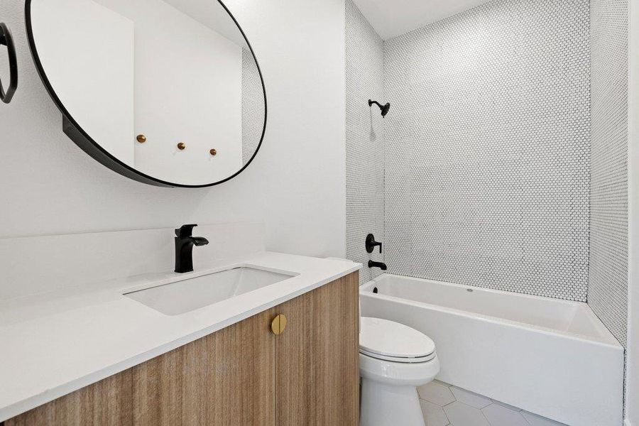 Full bath featuring bathing tub / shower combination, vanity, and light tile patterned floors