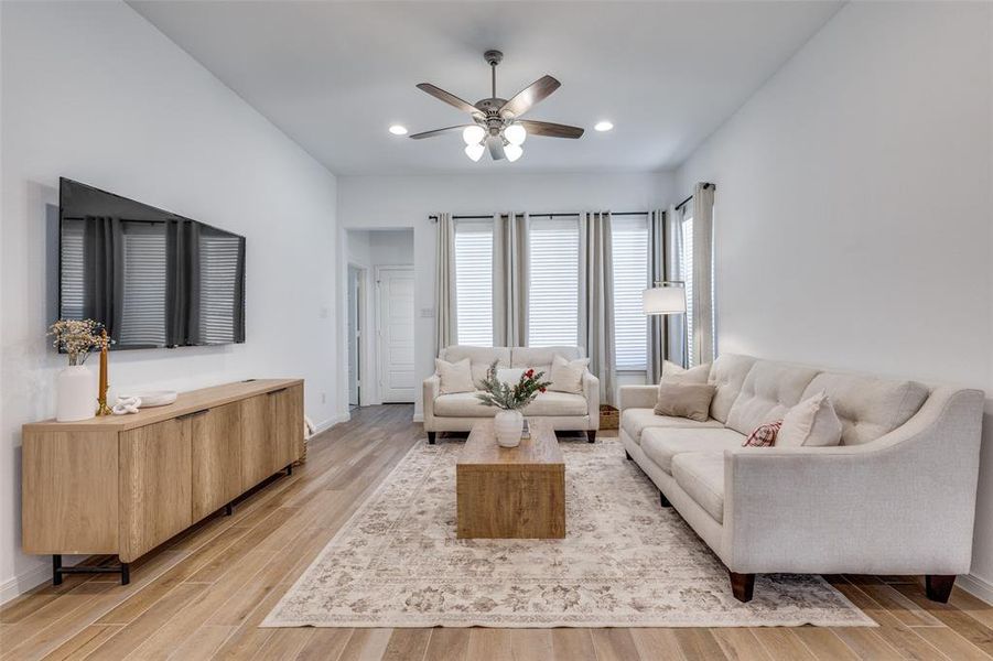 Living area with light wood finished floors, a ceiling fan, and recessed lighting