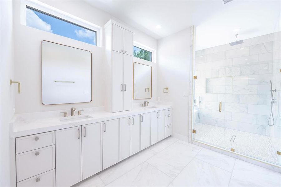 Bathroom featuring a shower with shower door, dual vanity, and tile flooring Bathroom featuring a shower with shower door, dual vanity, and tile flooring
