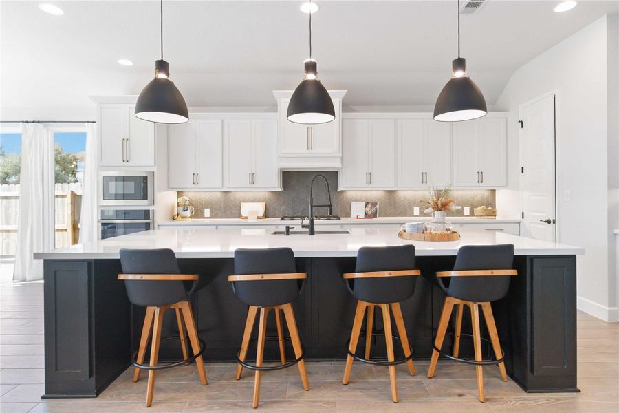 Kitchen featuring recessed lighting, tasteful backsplash, hanging light fixtures, light wood-style flooring, and a large island Kitchen featuring recessed lighting, tasteful backsplash, hanging light fixtures, light wood-style flooring, and a large island