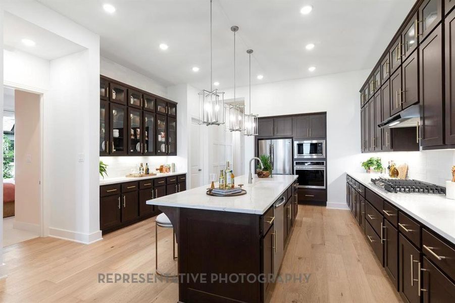 Kitchen with glass insert cabinets, dark brown cabinets, and recessed lighting